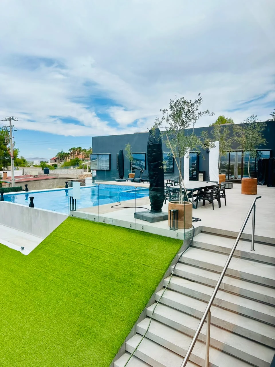 Terraza con pasto, alberca y área de descanso de Casa Martínez