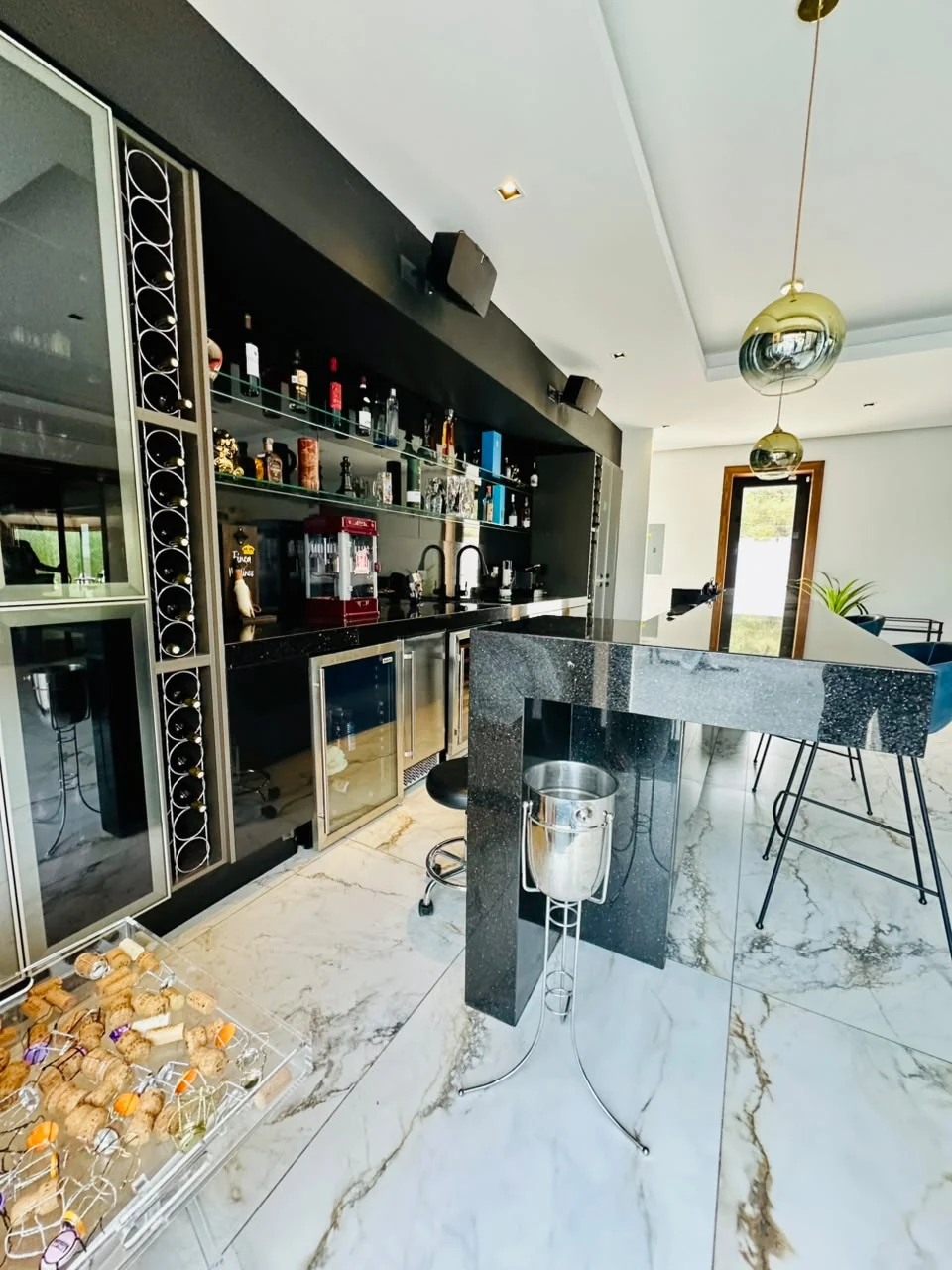 Barra completa en granito negro con cava de vinos en Casa Martínez