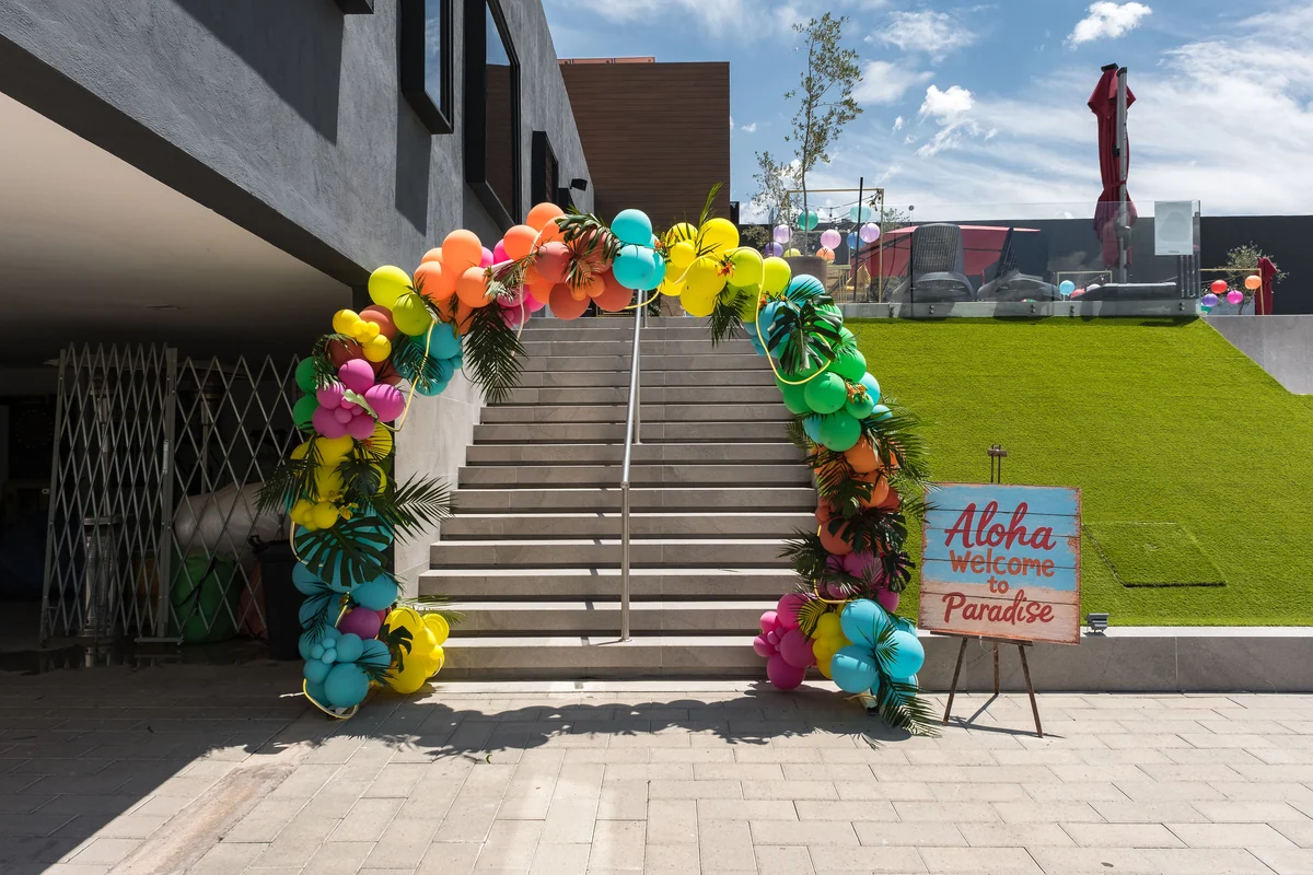 Escalera hacia el jardín de Casa Martínez decorada con arco de globos para un evento