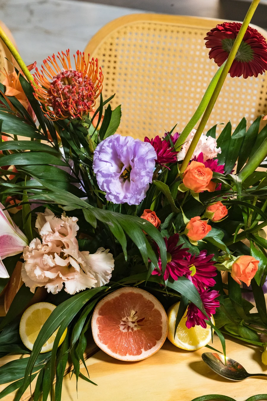 Arreglo floral tropical con toronja y hojas de palma