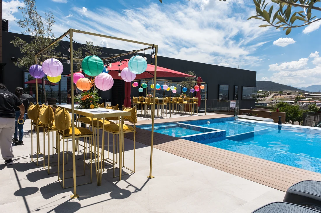 Terraza con mesa alta y globos junto a la alberca de Casa Martínez