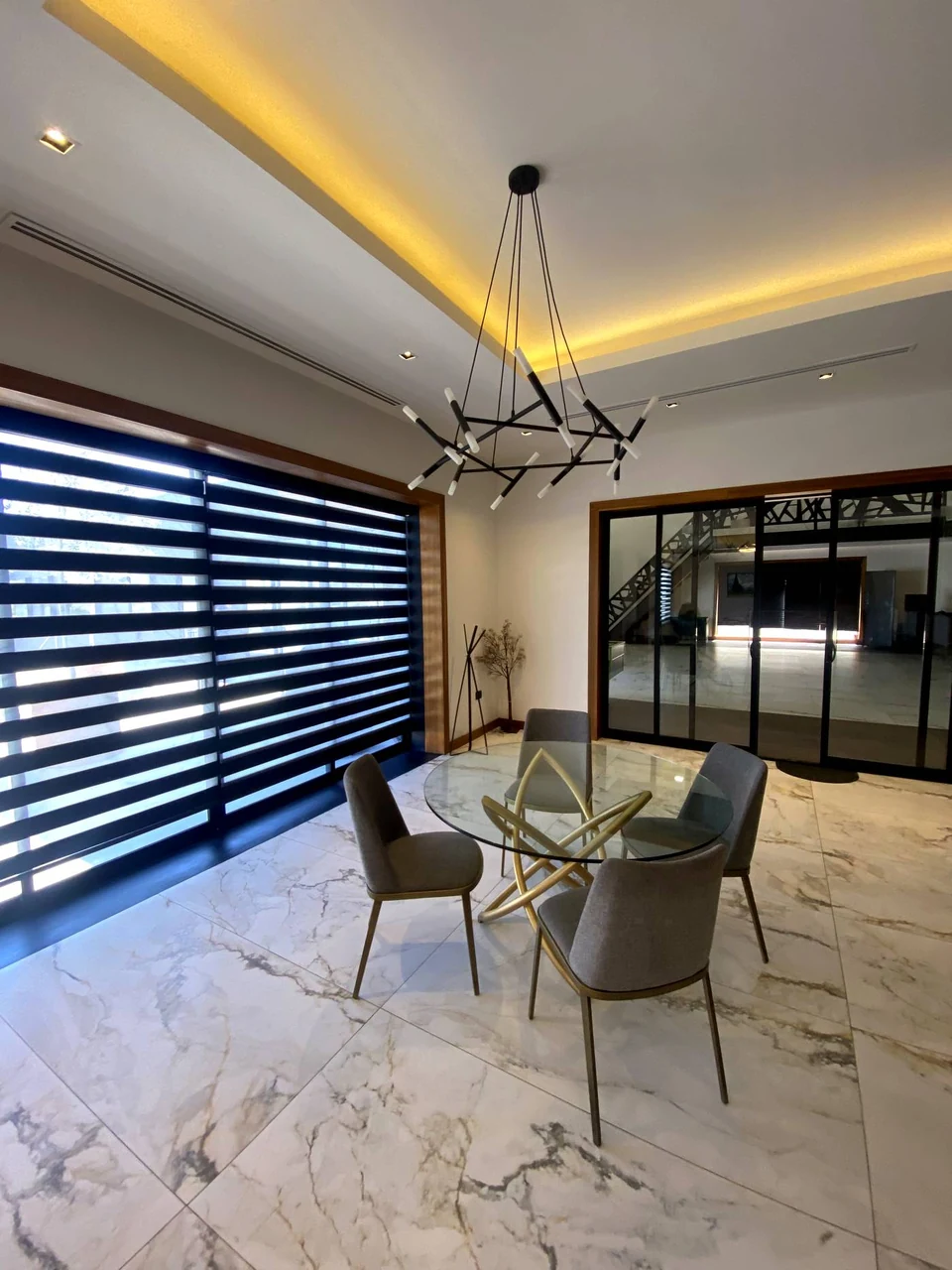 Interior de Casa Martínez con comedor, piso de mármol y candil