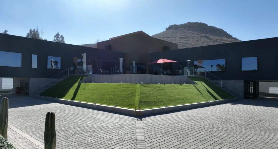Fachada de Casa Martínez con jardín inclinado y el cerro al fondo, Chihuahua
